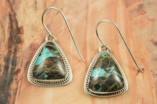 Genuine Sunnyside Turquoise set in Sterling Silver French Wire Earrings. The matrix on this rare stone is outstanding. The Sunnyside mine is located in northern Nevada near the town of Tuscarora in the Tuscarora mountain range. The mine is no longer in operation as it has become part of a gold mining operation and a privately owned ranch. The Sunnyside mine was mined mostly in the 70's. You won't find much of this great turquoise around anymore except for old stashes. Created by Navajo Artist Milton Lee. Signed.